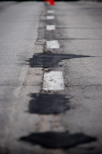 A road full of potholes has been patched up