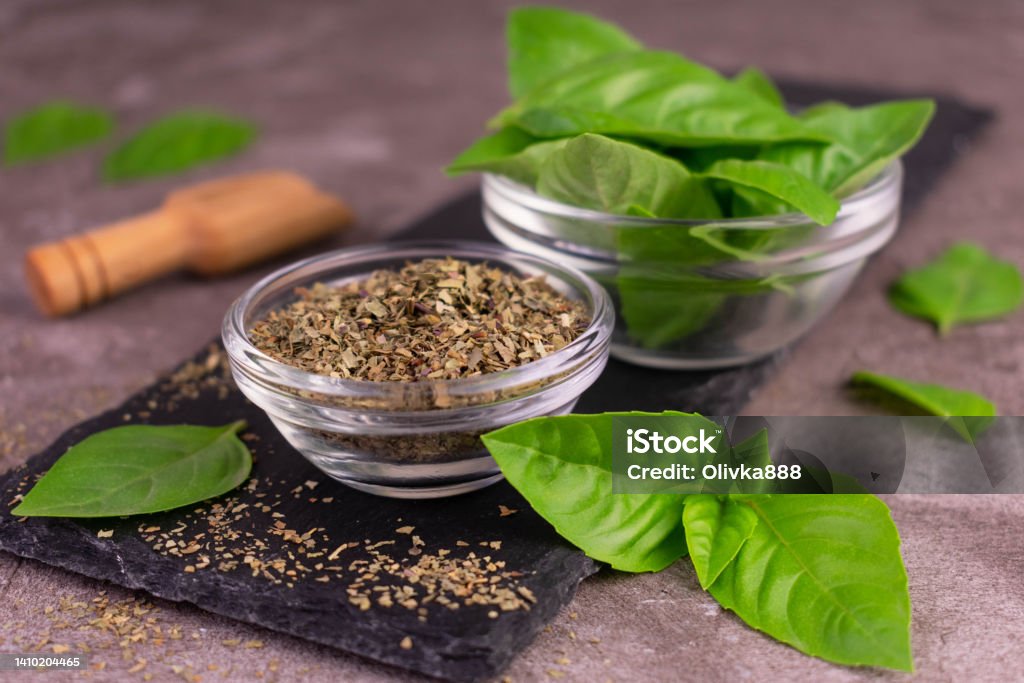 Fresh bezel leaves and dried basil on a black board. Aromatherapy Stock Photo