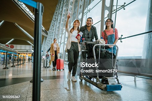 istock Asian family with luggage on trolley at airport 1410205367