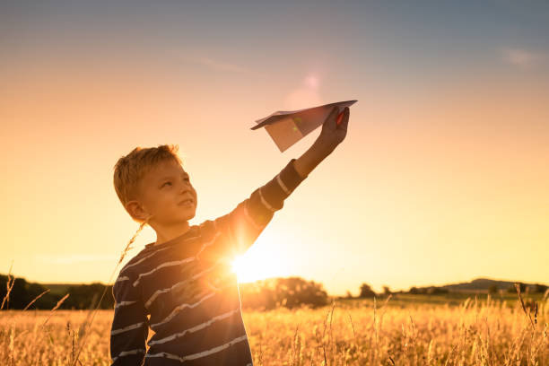 istock Happy boy playing with a paper airplane. 1410205514