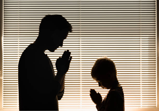istock Father and son praying together. 1410205523