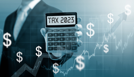 Tax 2023 on calculator. Business and tax concept .Businessman hold and show Calculator with word tax 2023. settlement income and property tax.