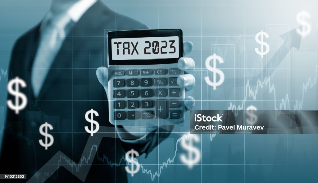 Tax 2023 on calculator. .Businessman hold and show Calculator with word tax 2023. Concept of taxes paid by individuals and corporations such as VAT, income tax and property tax. Tax 2023 on calculator. Business and tax concept .Businessman hold and show Calculator with word tax 2023. settlement income and property tax. Tax Stock Photo