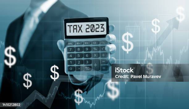 Tax 2023 On Calculator Businessman Hold And Show Calculator With Word Tax 2023 Concept Of Taxes Paid By Individuals And Corporations Such As Vat Income Tax And Property Tax Stock Photo - Download Image Now