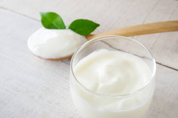 istock Yogurt cup and spoon on white wood background. 1410215348