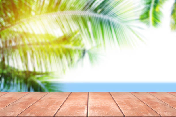 istock Empty wood table with blur coconut tree and sunlight on sea view. 1410217587