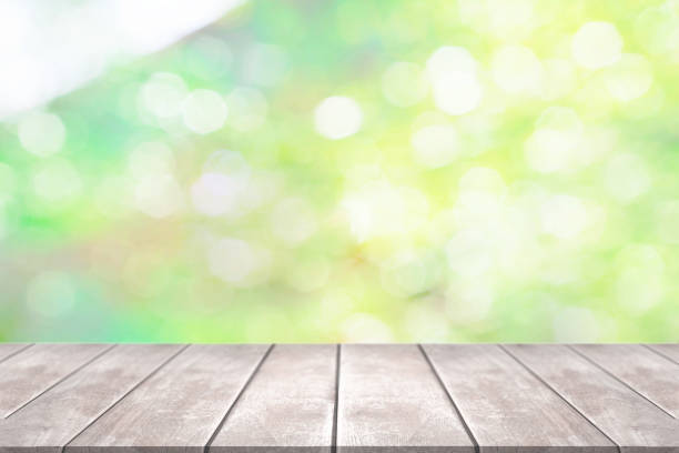istock Empty light wood table with green blur background. 1410217597