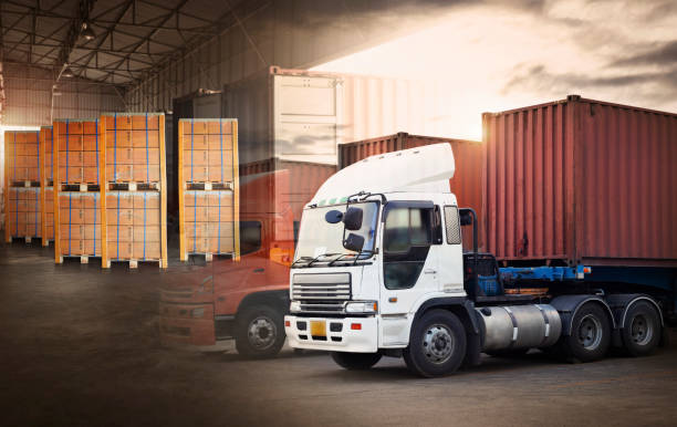 istock Double Exposure of Semi TrailerTrucks on Parking. Packaging Boxes Stacked on Pallets Loading into Cargo Container. Shipping Trucks. Supply Chain. Freight Trucks. Distribution Logistics Warehouse. 1410217705