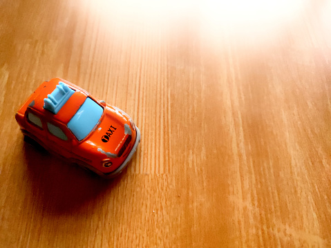Taxi toy car was shot on wooden floor with a little lightning