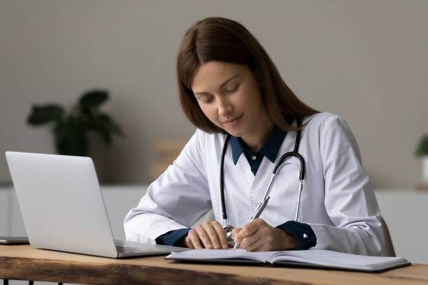 istock Concentrated young woman medical worker take notes at workplace 1410223223
