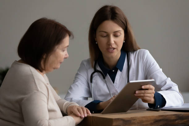 une femme médecin montre le résultat du test sur tablette pc au patient - general practitioner photos et images de collection