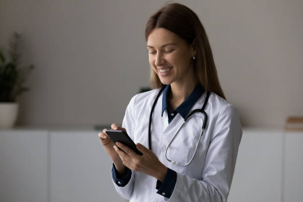 istock Smiling young lady doctor hold cellphone make call to patient 1410223247