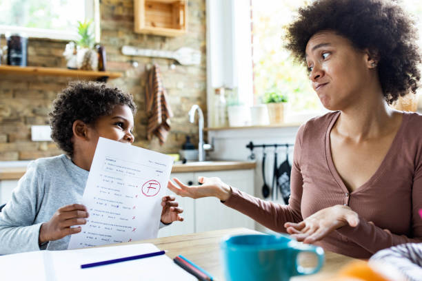 What should we do, even an F is a grade! Sad African American single mother looking at bad test results of her small boy at home. report card letter f test results education stock pictures, royalty-free photos & images