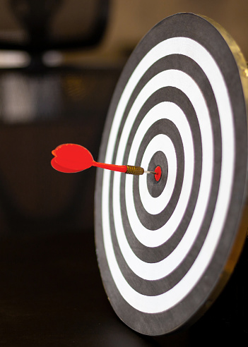 Three yellow darts hitting the target in a game of darts scoring a bulls eye. Copy space