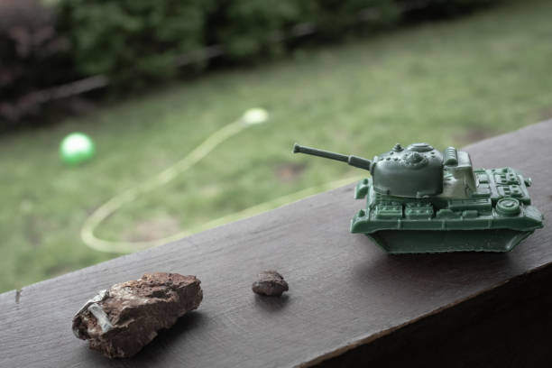 istock Toy tank next to a fragment of a combat shell 1410225081