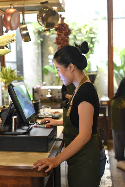 istock Young vietnamese waitress serving a customer at the checkout in cafe 1410226765