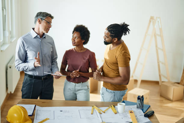 istock Male architect talking to black couple during home renovation process. 1410227102