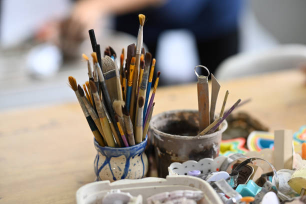 istock Ceramics making equipment with paint brushes, pottery shaping tools on wooden table in creative studio. 1410229380