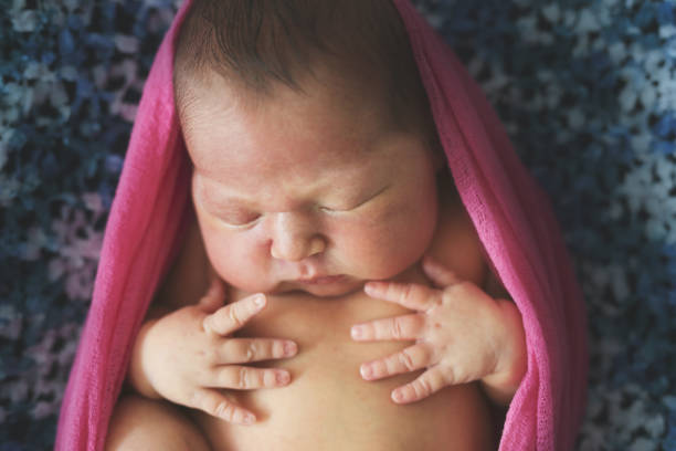 istock tender newborn baby sleeping on a dark blue 1410230123