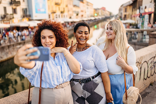 Group of females taking a selfie near the river in the city