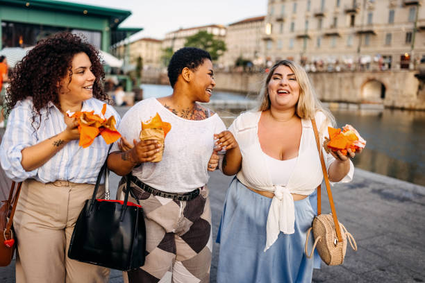 amis, manger fast-food dans la rue - people eating walking fun photos et images de collection