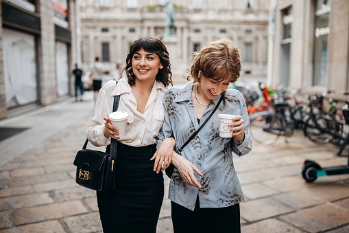 Two young businesswoman enjoying coffee in a city