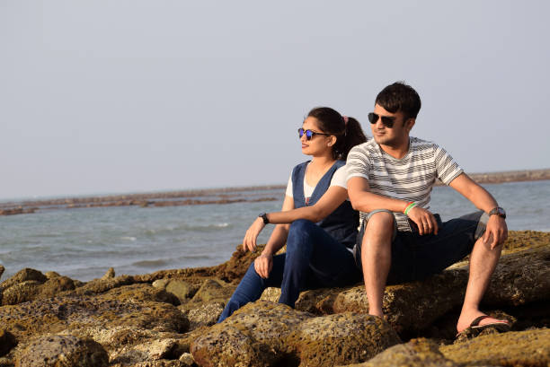 hombre y mujer jóvenes disfrutando de la belleza de la naturaleza, la playa de mar más larga sentada en el coral. pareja que pasa el tiempo de luna de miel - honeymoon beach couple heterosexual couple fotografías e imágenes de stock