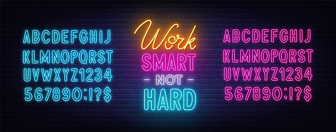 Work Smart Not Hard neon quote on a brick wall. Inspirational glowing lettering. Blue and pink neon alphabets.