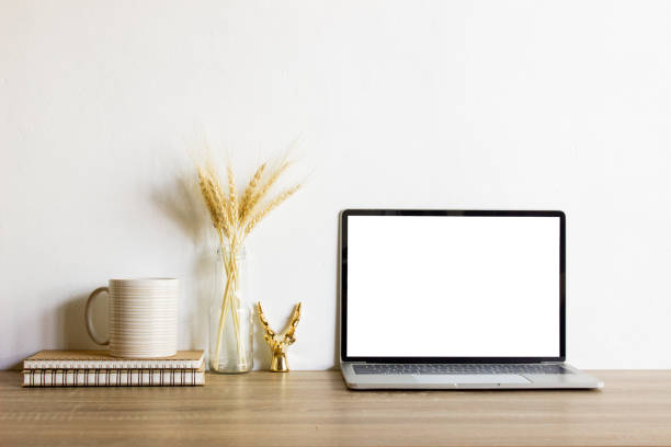istock Mock up computer with coffee cup and natural flower and notebook over the wooden table. 1410248803