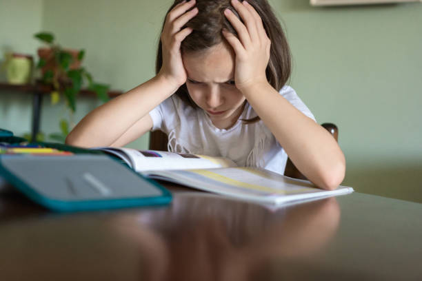 istock Tired girl reading a book at home 1410251875