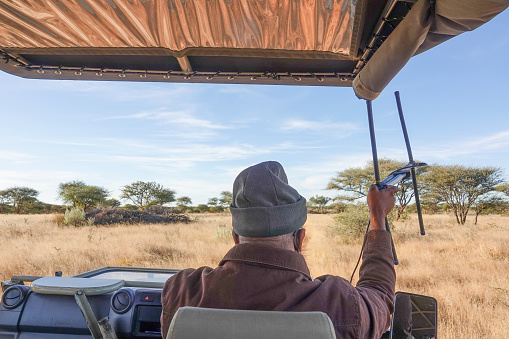 Arusha,Tanzania,Africa. 04.02.2022. several special safari jeeps stand on the road in Ngorongoro National Park in Africa against backdrop of volcano crater funnel. Safari game drive with wildebeest