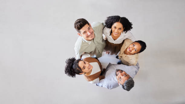 Smiling businesspeople standing arm in arm in a circle