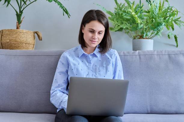 istock Young woman working from home using laptop 1410259144