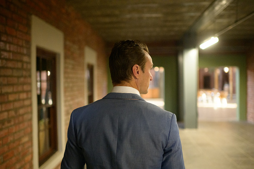 Rear view Business Casual dressed business man walking in corridor