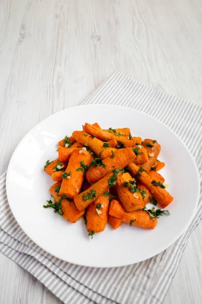 istock Homemade Roasted Carrots with Herbs on a white plate, side view. Copy space. 1410267458