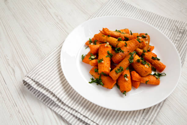 istock Homemade Roasted Carrots with Herbs on a white plate, side view. Space for text. 1410267485