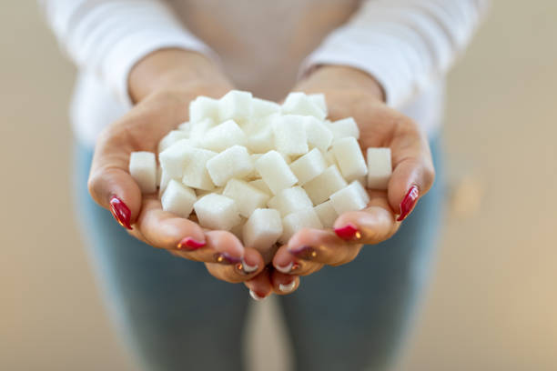 Female hands holding sugar cubes Female hands holding sugar cubes sugar cube stock pictures, royalty-free photos & images