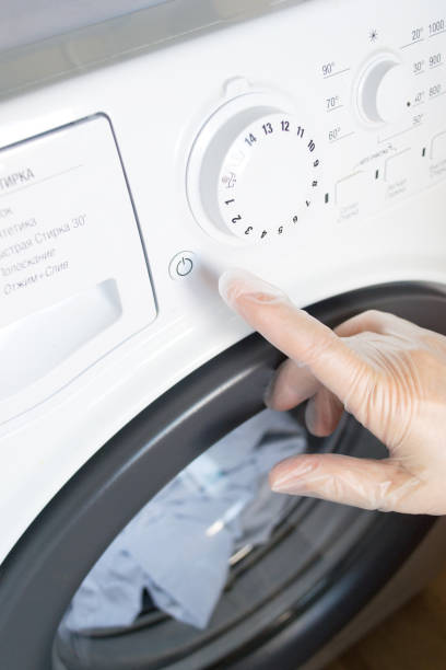 istock A woman's hand presses a button on the washing machine. 1410269231