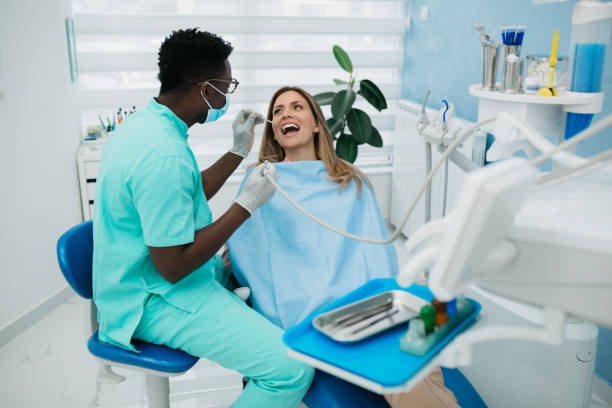 A professional dentist carefully working with his female patient stock photo