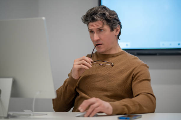 istock A man sitting at the computer and looking concentrated 1410273244