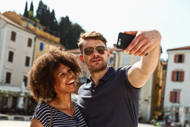 istock Mixed race couple taking selfies 1410274116