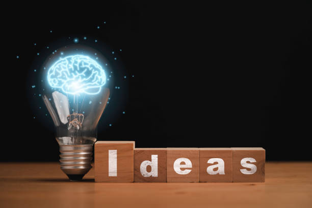 istock Virtual blue brain inside of lightbulb with Idea wording on wooden cube block for creative thinking idea and problem solving after study knowledge concept. 1410274216