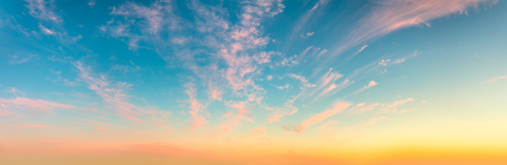 Gentle romantic pink cirrus clouds in the dawn sky. Delicate mood of the Sunrise Sundown Sunset sky. Panorama. There are no birds in the sky