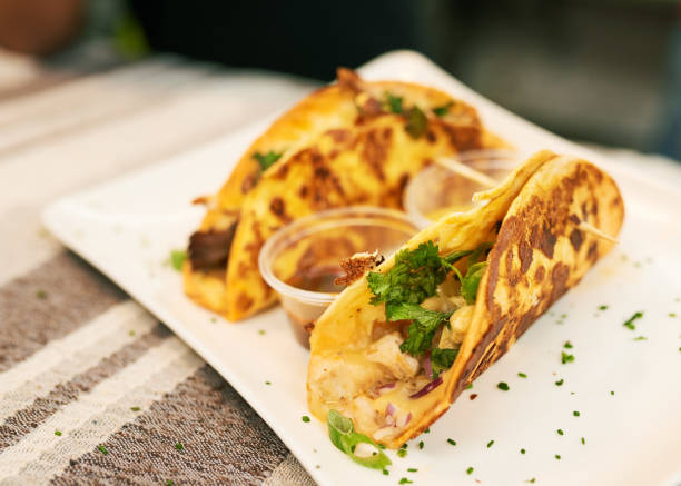 istock Two soft shell tacos at a market, one with chicken one with beef 1410282266