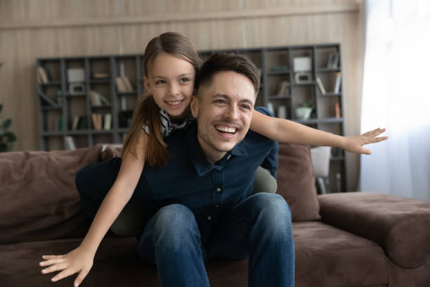 istock Happy young father holding on back joyful kid daughter. 1410282284