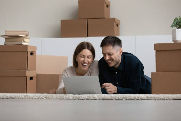 istock Happy laughing young family couple using computer, planning decorations. 1410282323