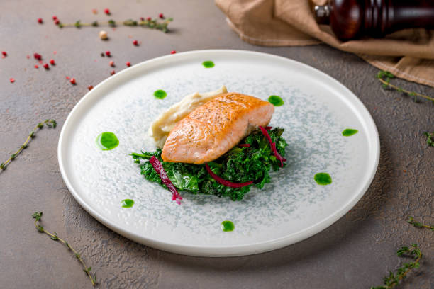 istock Salmon steak on the grill spinach and mashed selery on plate 1410284053