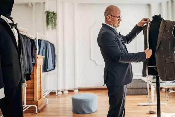 Male fashion designer making a jacket for a suit in his design clothing studio.