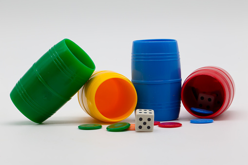 Colored cup with chips and dice to play Parcheesi.  Table games.  Family games