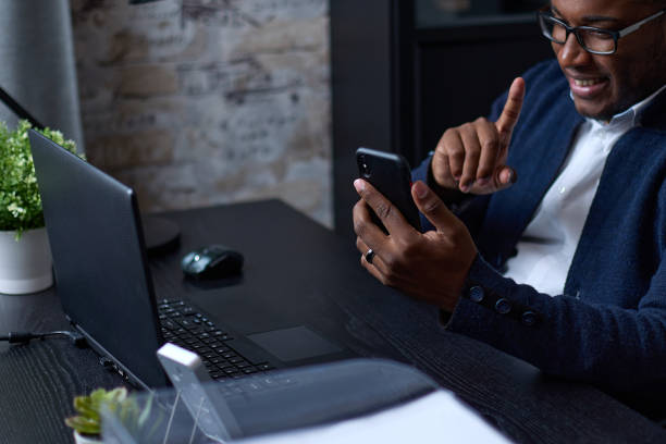 istock Positive African businessman using a mobile smartphone 1410285732